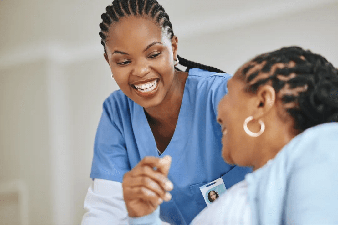 A smiling clinician speaking with a patient.